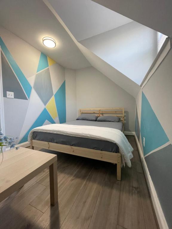 ein Schlafzimmer mit einem Bett mit einer farbenfrohen Wand mit Akzenten in der Unterkunft 1Guest House Baltimore County (own room, Joppa RD) in Parkville