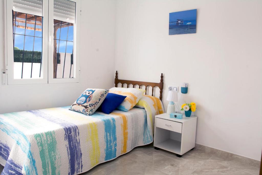 Schlafzimmer mit einem Bett und einem Fenster in der Unterkunft CASA SOLEADA. Intimidad, piscina y mucho sol. in Santiago de la Ribera