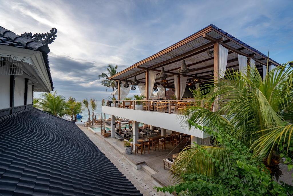 un bâtiment avec un restaurant sur la plage dans l'établissement Ohana's Beachfront Resort & Beach Club, à Nusa Lembongan