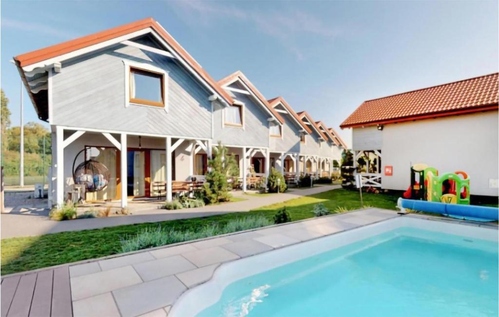 a home with a swimming pool and a house at Awesome Home In Karwia With Outdoor Swimming Pool in Karwia