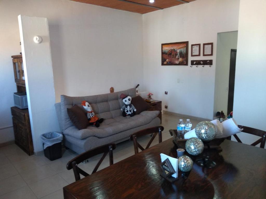 ein Wohnzimmer mit einem Sofa und einem Tisch in der Unterkunft Casa Alebrijes in Tequila