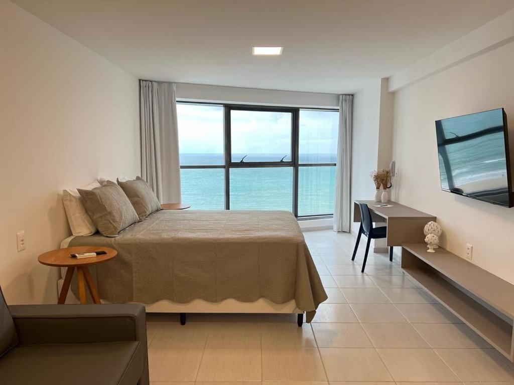 1 dormitorio con cama y vistas al océano en BEACH CLASS INTERNATIONAL - Flat beira mar, en Recife
