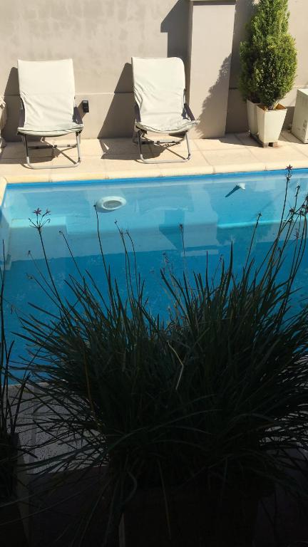 una piscina con 2 tumbonas junto a ella en Loft Urbano en Tandil