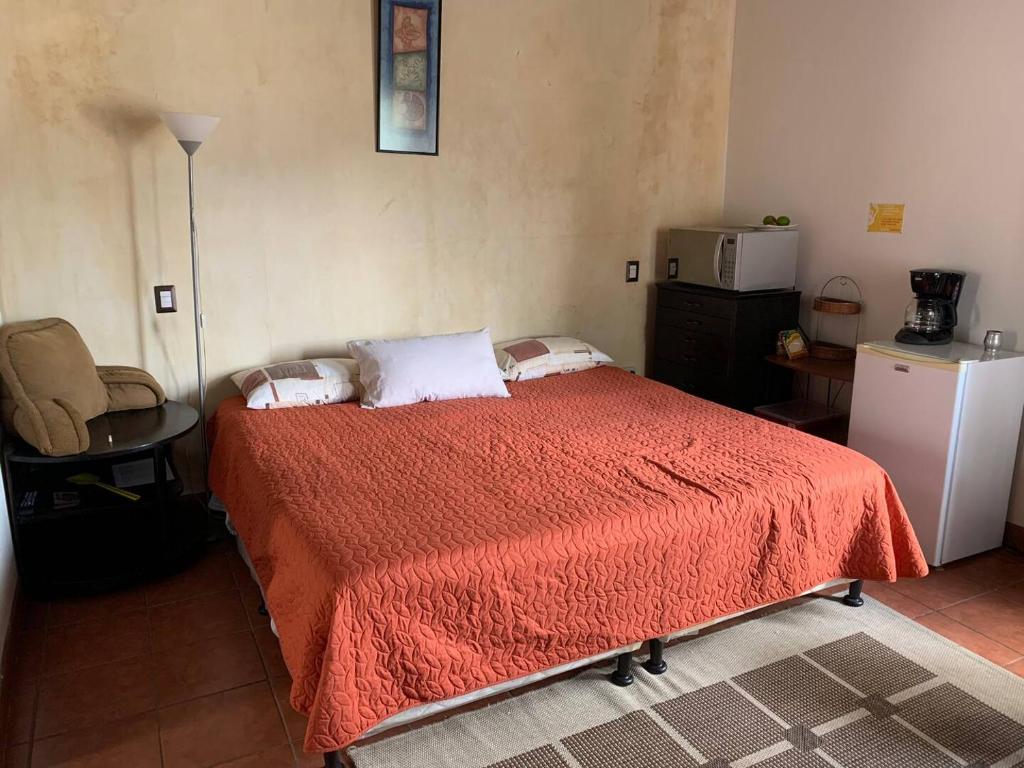 a bedroom with a bed with a red blanket at Colonial Charm in Antigua - women only in Antigua Guatemala