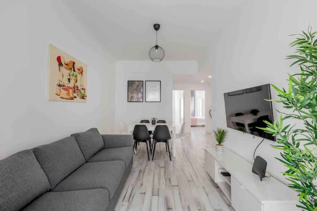 a living room with a couch and a table and chairs at Lovely 3-bedroom condo w/ free parking on premises in Queluz