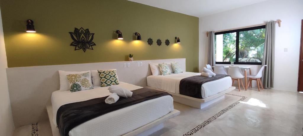 1 dormitorio con 2 camas, mesa y sillas en Valentina Holbox, en Isla Holbox