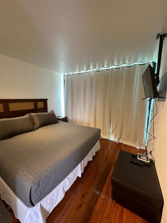 um quarto com uma cama e uma mesa com uma televisão em Linda Vista em Iquique