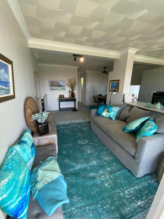 a living room with a couch and a green rug at Aqua on Bribie 100 metres to Beach and Shops in Bongaree