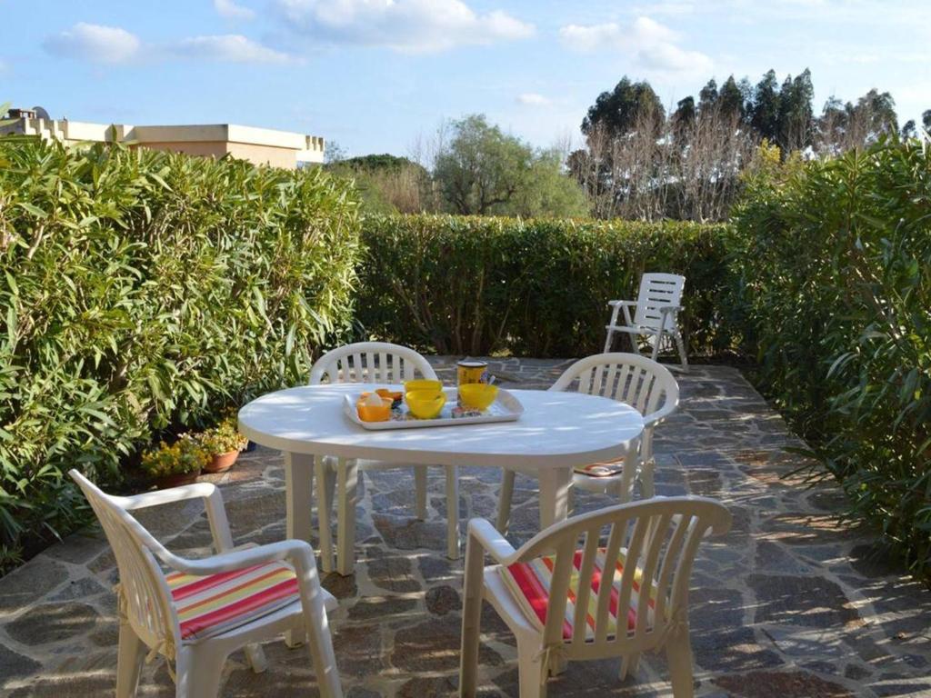 - une table et des chaises blanches avec une assiette de fruits dans l'établissement Studio cabine avec terrasse et parking, à 250 m de la plage d'Aiguebelle, Le Lavandou - FR-1-251-187, au Lavandou