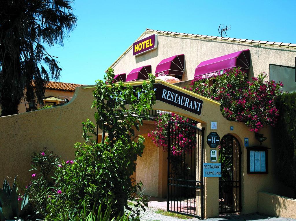 a restaurant with flowers on the front of a building at Longo Mai in Le Sambuc