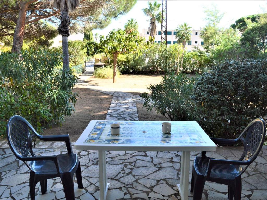 - une table et deux chaises avec deux tasses dans l'établissement Studio cosy avec jardin, proche plage à Cavalaire-sur-Mer, parking inclus - FR-1-226B-128, à Cavalaire-sur-Mer