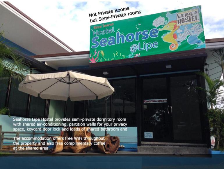 a restaurant with an umbrella in front of a store at Seahorse Lipe Hostel in Ko Lipe