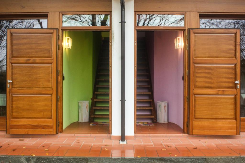 Cette chambre dispose de deux portes en bois et d'un mur vert. dans l'établissement Agriturismo Il Frutto Permesso, à Bibiana