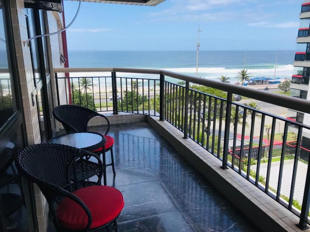 balcón con mesa, sillas y vistas al océano en Apartamento Praia Orla Barra da Tijuca, en Río de Janeiro