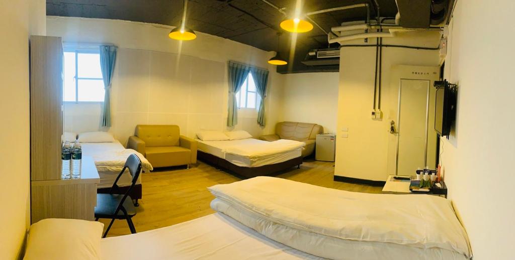 a hospital room with two beds and a couch at EasyInn Hotel &amp; Hostel in Tainan