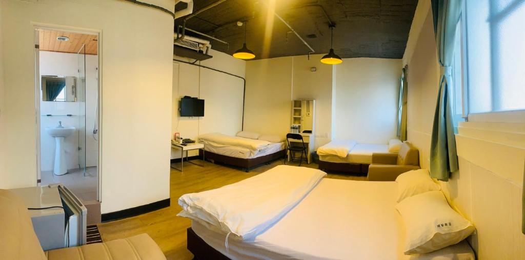 a hospital room with two beds and a mirror at EasyInn Hotel &amp; Hostel in Tainan