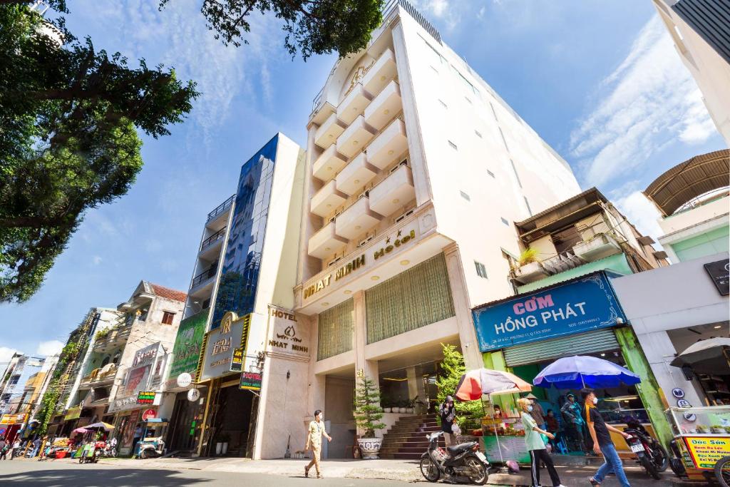 胡志明市的住宿－Nhat Minh Hotel - Etown and airport，街上的一座建筑,街上的人在街上行走