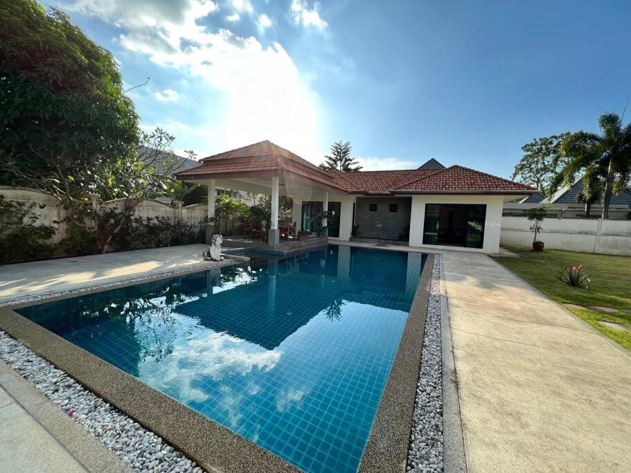 a swimming pool in front of a house at Maya Villa by G Estate in Rawai Beach