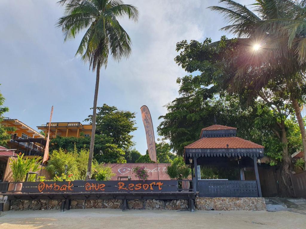 a bench in a park with a monument in the background at Ombak Dive Resort Perhentian Island in Perhentian Islands