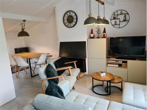 a living room with a couch and a tv and a table at Groendijk 105 in Koksijde