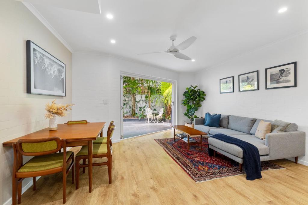 a living room with a couch and a table at Little cove gem - walking distance to the most famous Noosa beach! in Noosa Heads