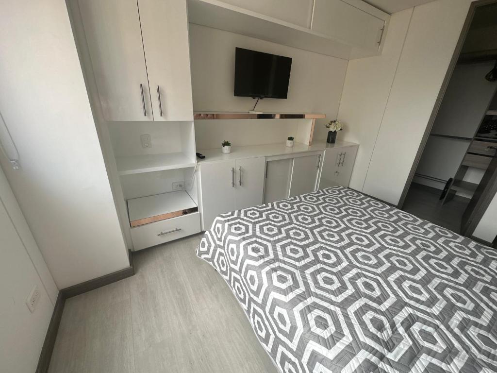 1 dormitorio blanco con 1 cama y TV en Sabaneta lujoso 3 habitaciones, en Medellín