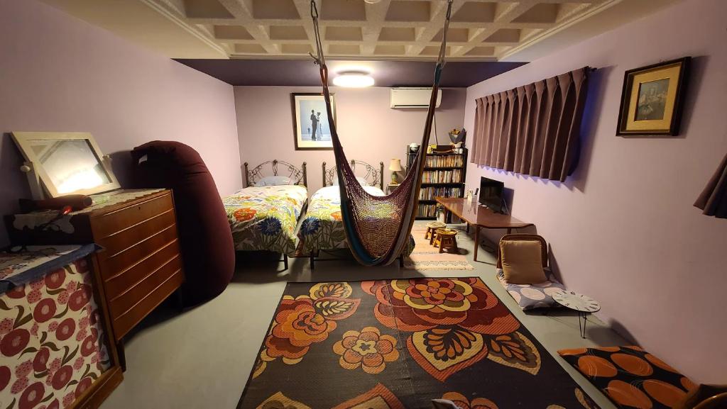 Haruka 紫 في ناها: غرفة نوم مع سرير ومرجيح كبير