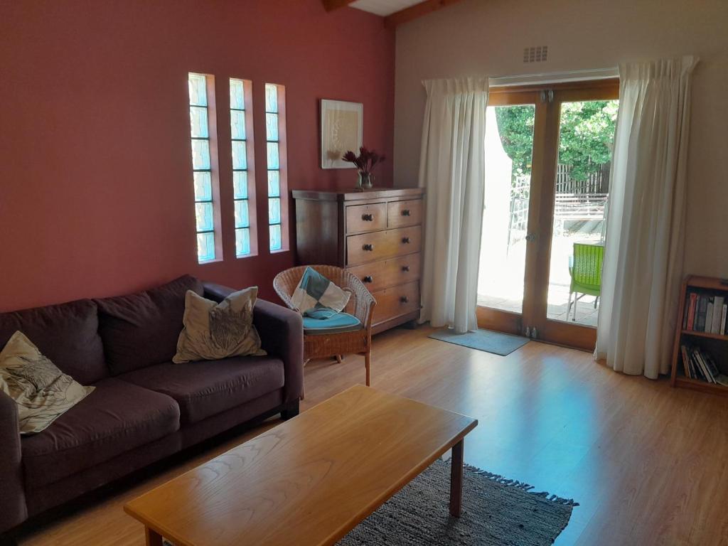 a living room with a couch and a table at Dorset Cottage in Cape Town