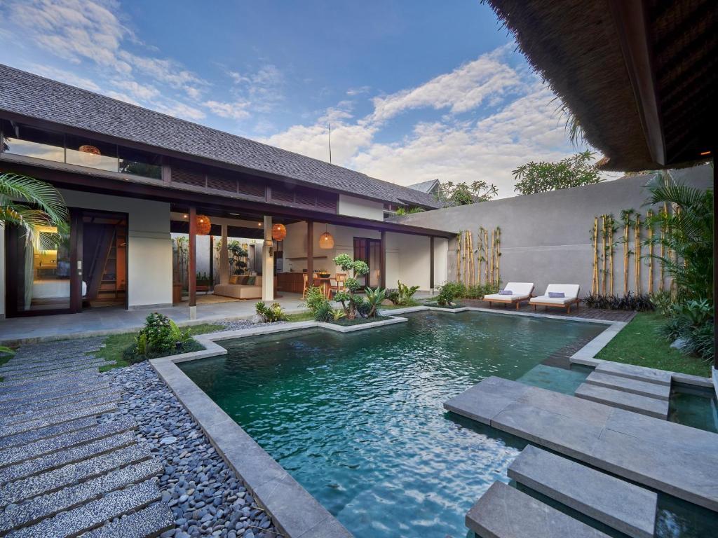 a swimming pool in the backyard of a house at Bumbak Park Villas in Canggu