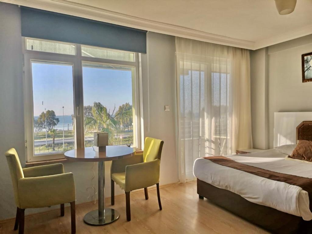 フィニケにあるHotel Simsekのベッド、テーブル、椅子が備わるホテルルームです。