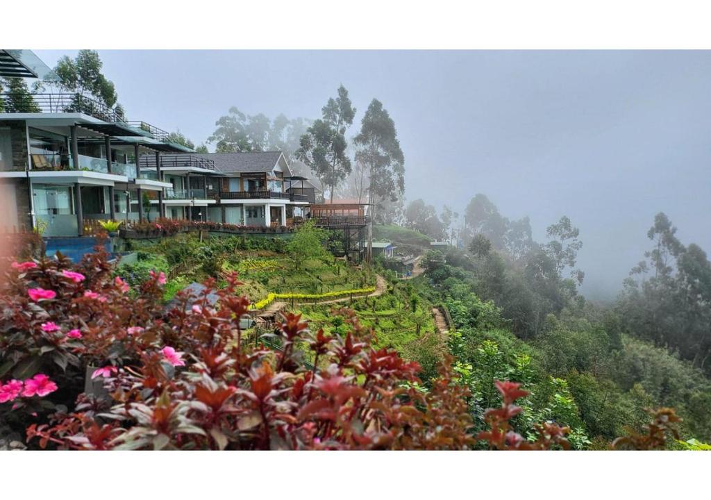 a house on the side of a hill with flowers at Chandys Drizzle Drops - Munnar Top Station in Munnar