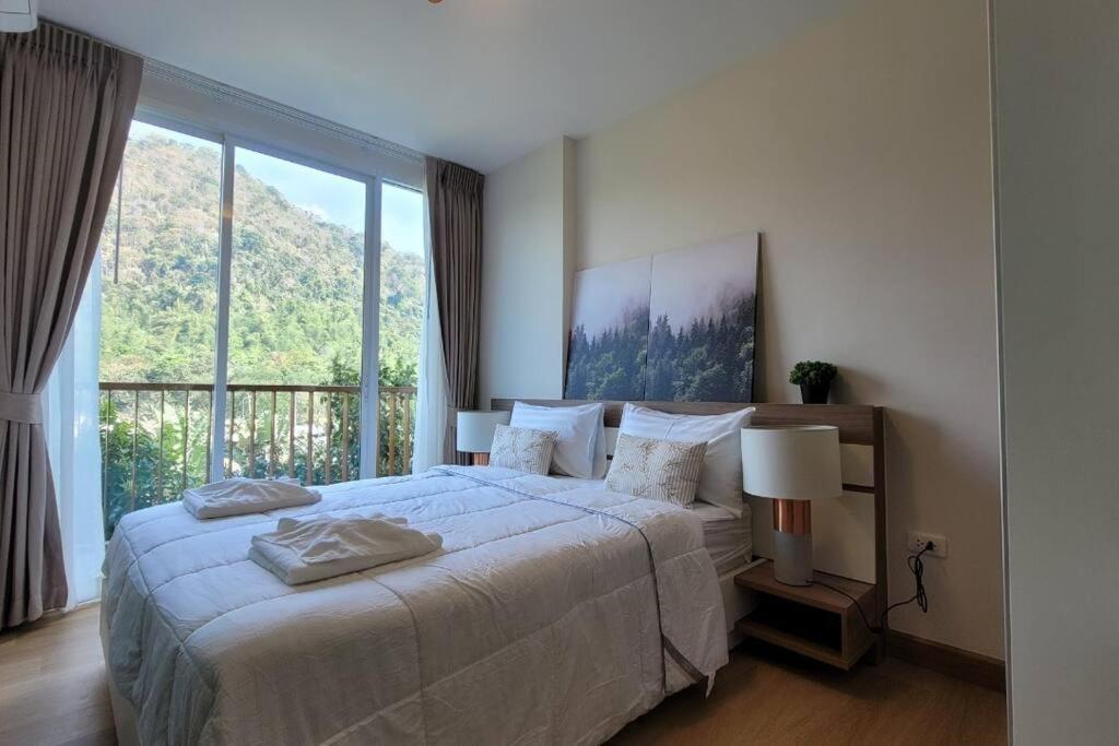una camera con un grande letto e una grande finestra di Baan Khaoyai cozy a Ban Tha Maprang