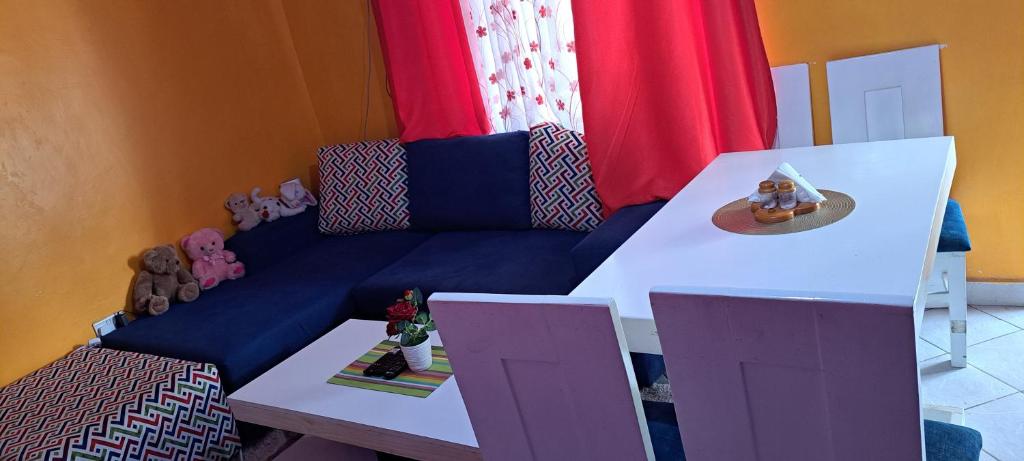 uma sala de estar com um sofá azul com bichos de peluche em One bedroom Apartment em Praia de Diani