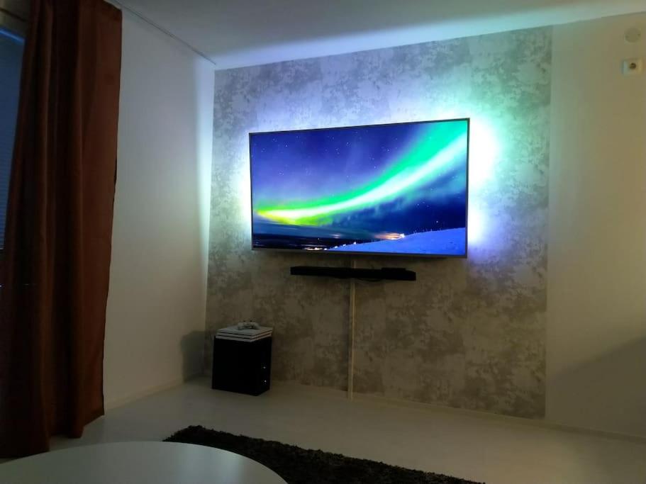 una TV a schermo piatto appesa a un muro di Rivitalon pieni päätykaksio - 37 m2 a Jämsä