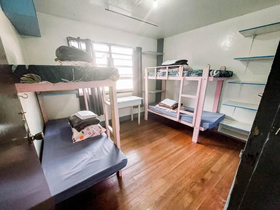 a room with bunk beds and a wooden floor at Convenient 3-Bedroom Apartment in Baguio