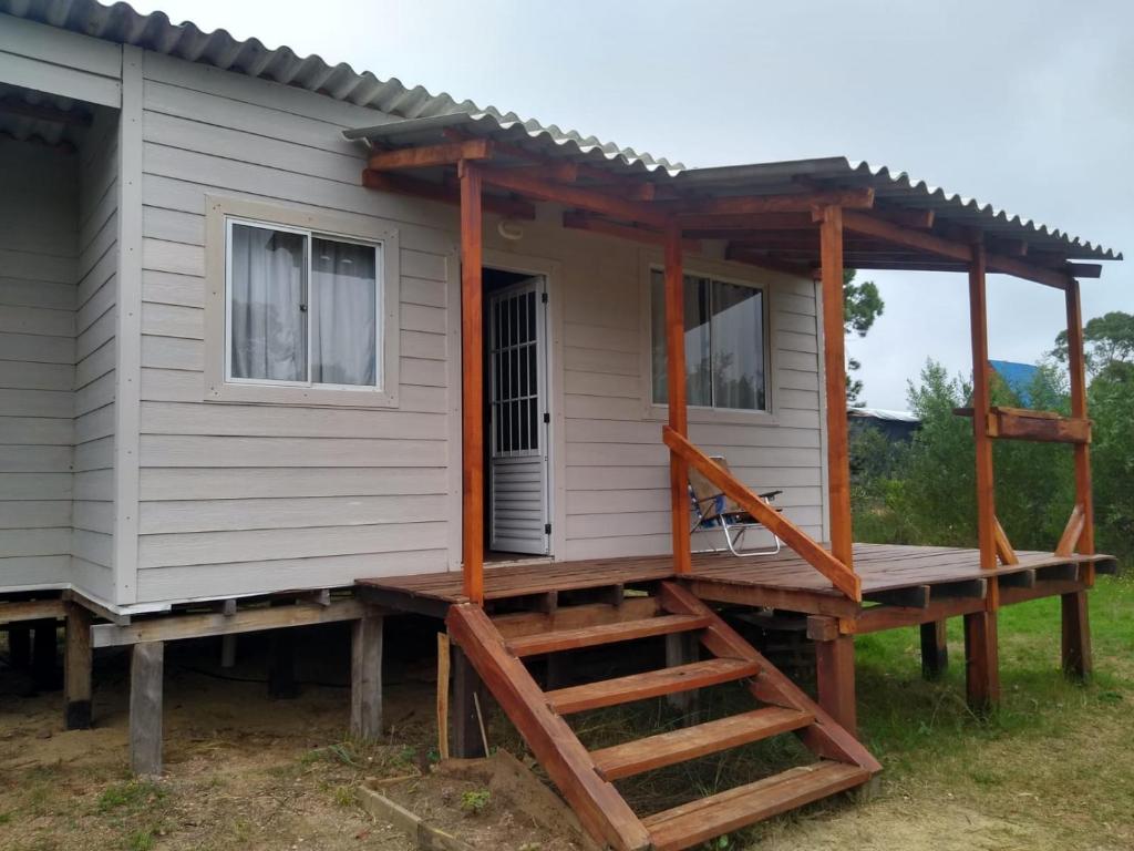 una casa pequeña con porche y escalera en Soleada, en Punta del Diablo