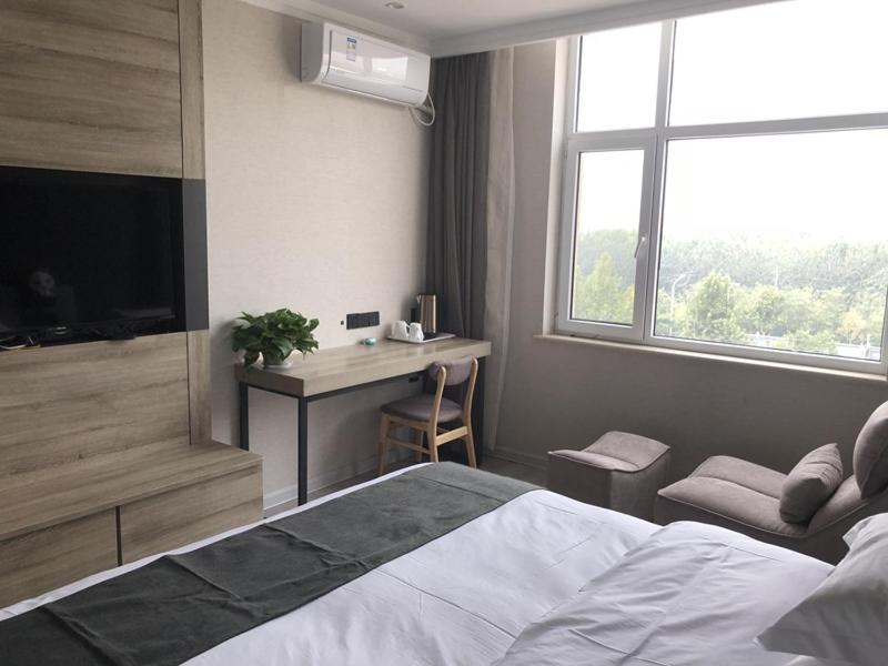 a bedroom with a bed and a desk and a window at Thank Inn Plus Hotel Hebei Shijiazhuang Yuhua District of Hebei Normal University in Shijiazhuang