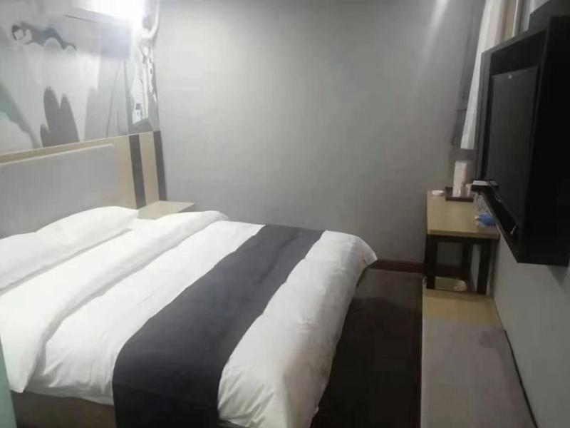 a bedroom with a bed and a flat screen tv at Thank Inn Chain Hotel hebei langfang gymnasium in Langfang