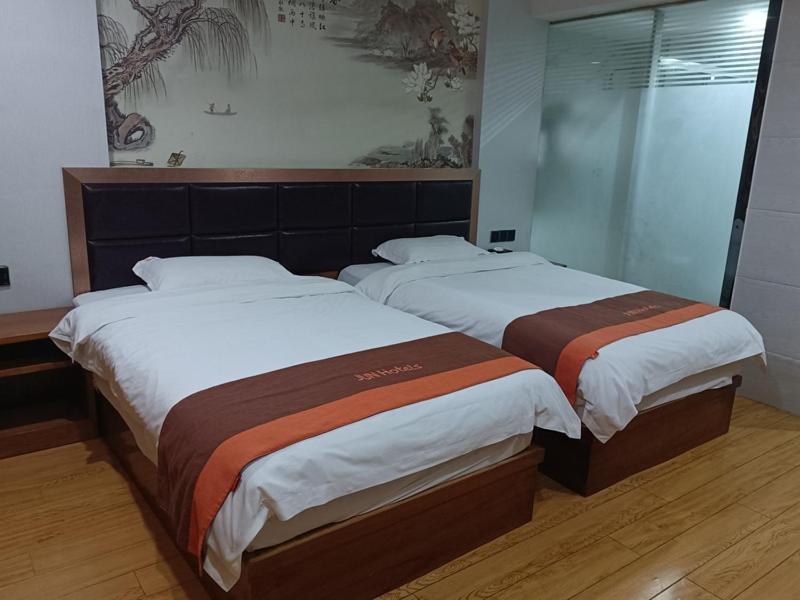two beds in a hotel room with at JUN Hotels Jiangxi Yingtan Yujiang County Railway Station Store in Yingtan