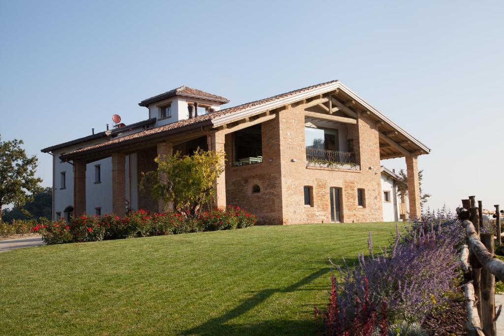 a large brick house with a grass yard at Agriturismo Alba Del Borgo in Fidenza