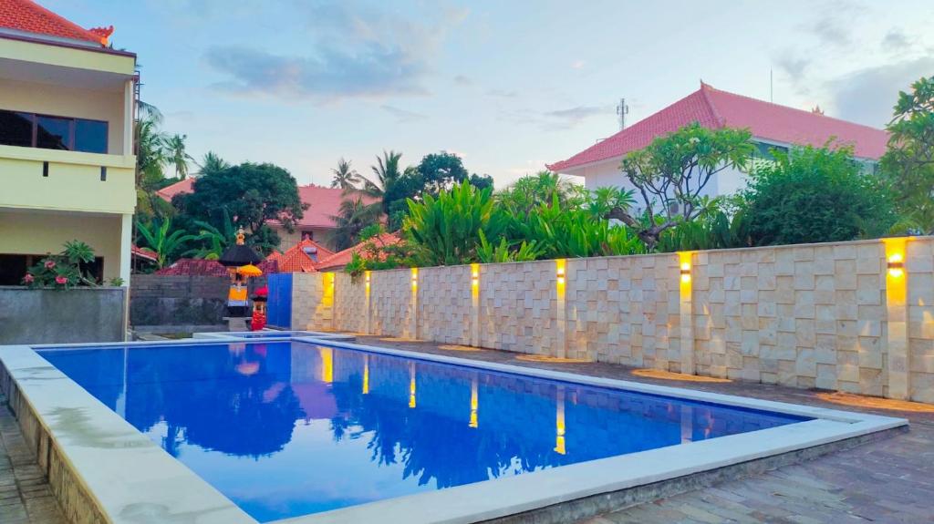 una piscina frente a una casa con una valla en THE LAVIANA HOTEL en Lovina