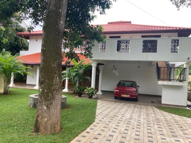 a red car parked in front of a house at GREEN Palace in Maharagama