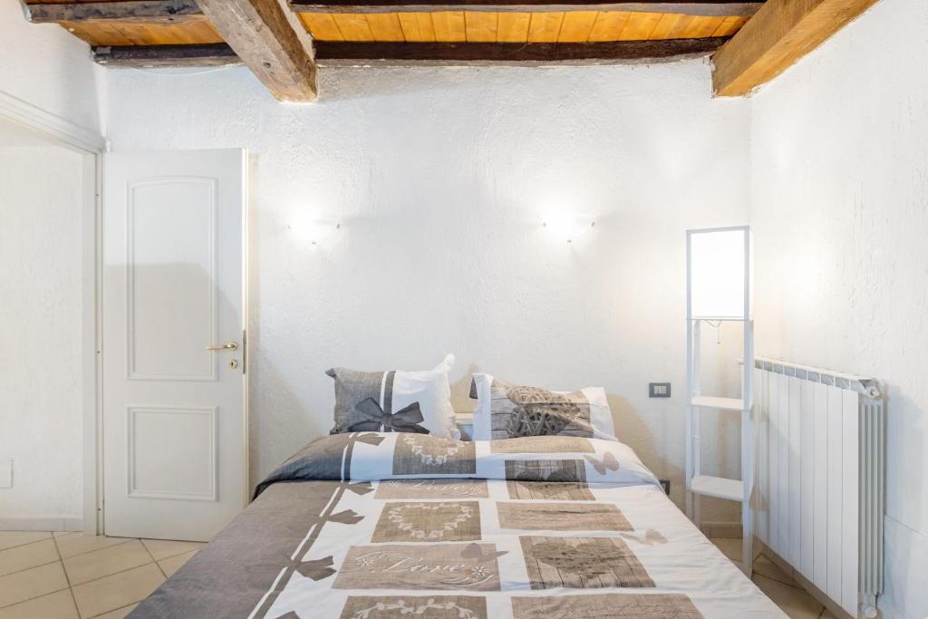 1 dormitorio con cama y pared blanca en Casa Romantica, en Massa