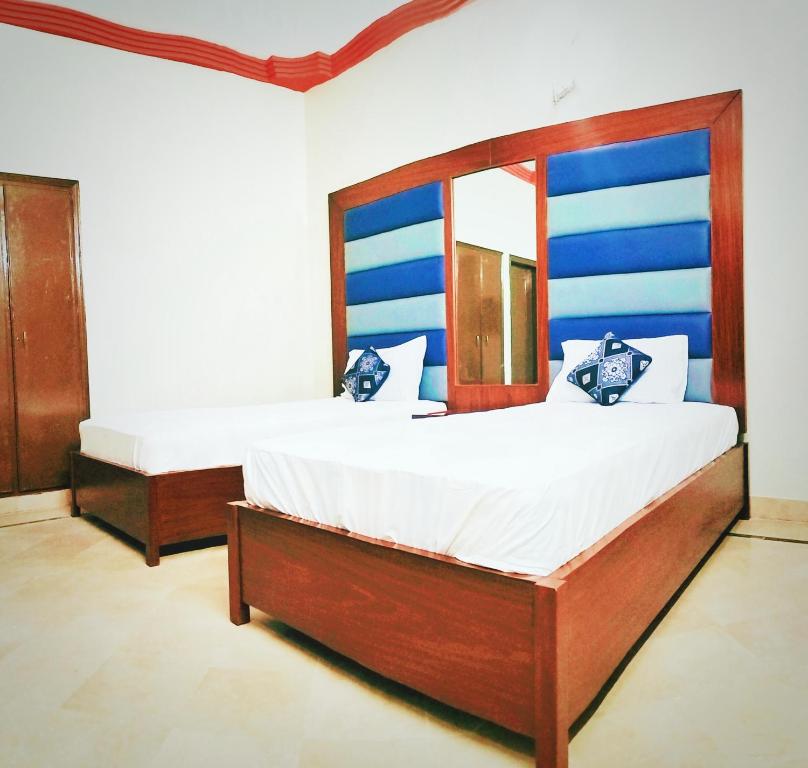 een slaapkamer met een groot bed en een spiegel bij GULSHAN E IQBAL Guest House Near Mallinum Mall & Agha Khan hospital in Karachi