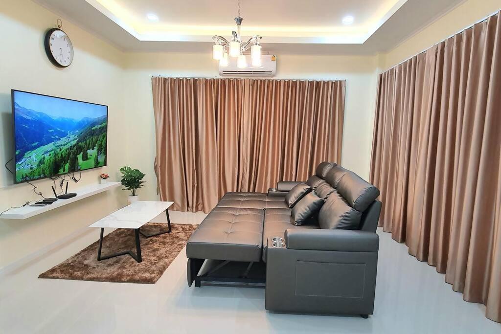 ein Wohnzimmer mit einem Sofa und einem TV in der Unterkunft Happy Family in Chanthaburi