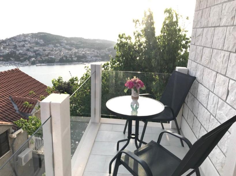 una mesa y sillas en un balcón con vistas en Sunset Rooms Dubrovnik, en Dubrovnik