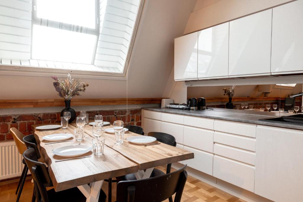 een keuken met een houten tafel met stoelen en een eetkamer bij 2ndhomes Luminous & Modern 107m2 Penthouse in Kruununhaka in Helsinki