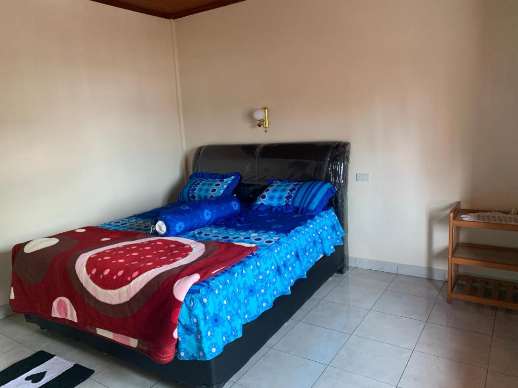um quarto com uma cama com edredão azul e vermelho em Anna’S em Tuktuk Siadong