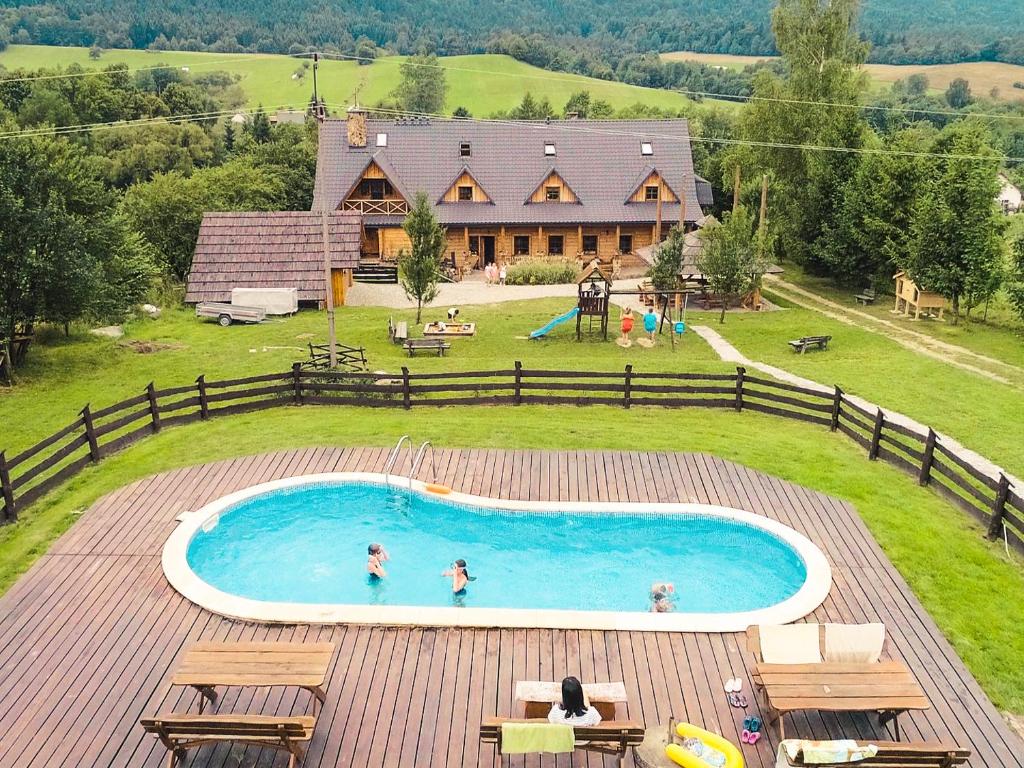 a house with a swimming pool with people in it at Gościniec Rabe - Agro&SPA in Ustrzyki Dolne