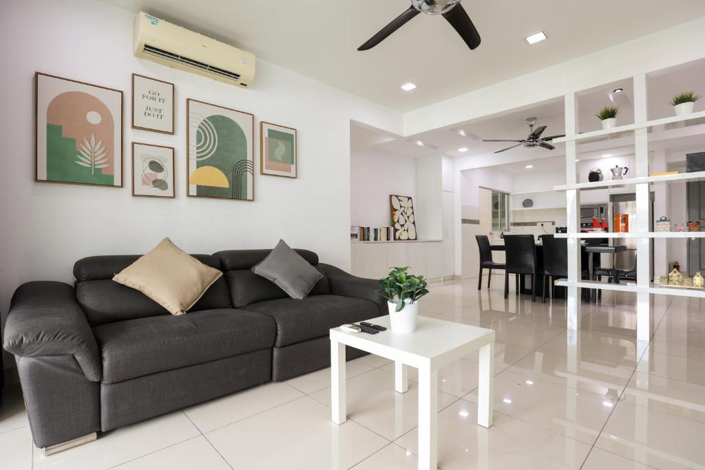 a living room with a black couch and a table at Cozy 2 bedroom w Pool - 6 Pax - Kajang in Kajang